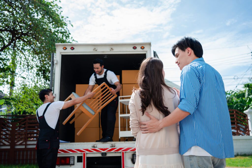Best Movers in Los Angeles CA Asian Couple check while unloading boxes and furniture from a pickup truck to a new house with service cargo two men movers worker in uniform lifting boxes. concept of Home moving and delivery.