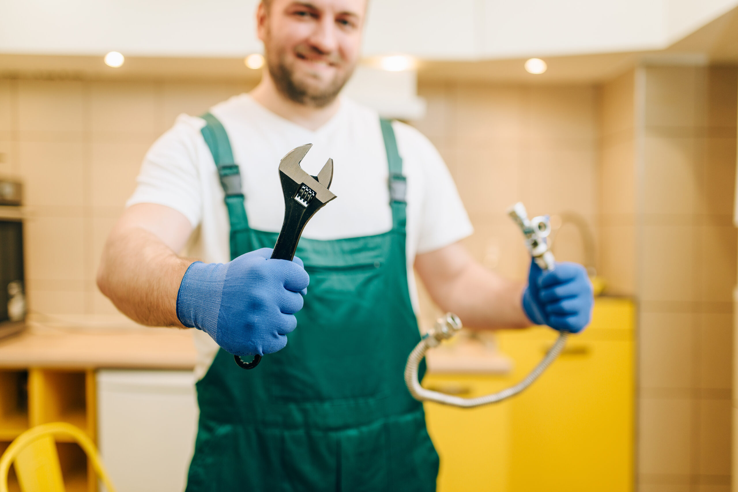 Plumbing Services Jackson TN Plumber in uniform holds wrench, handyman