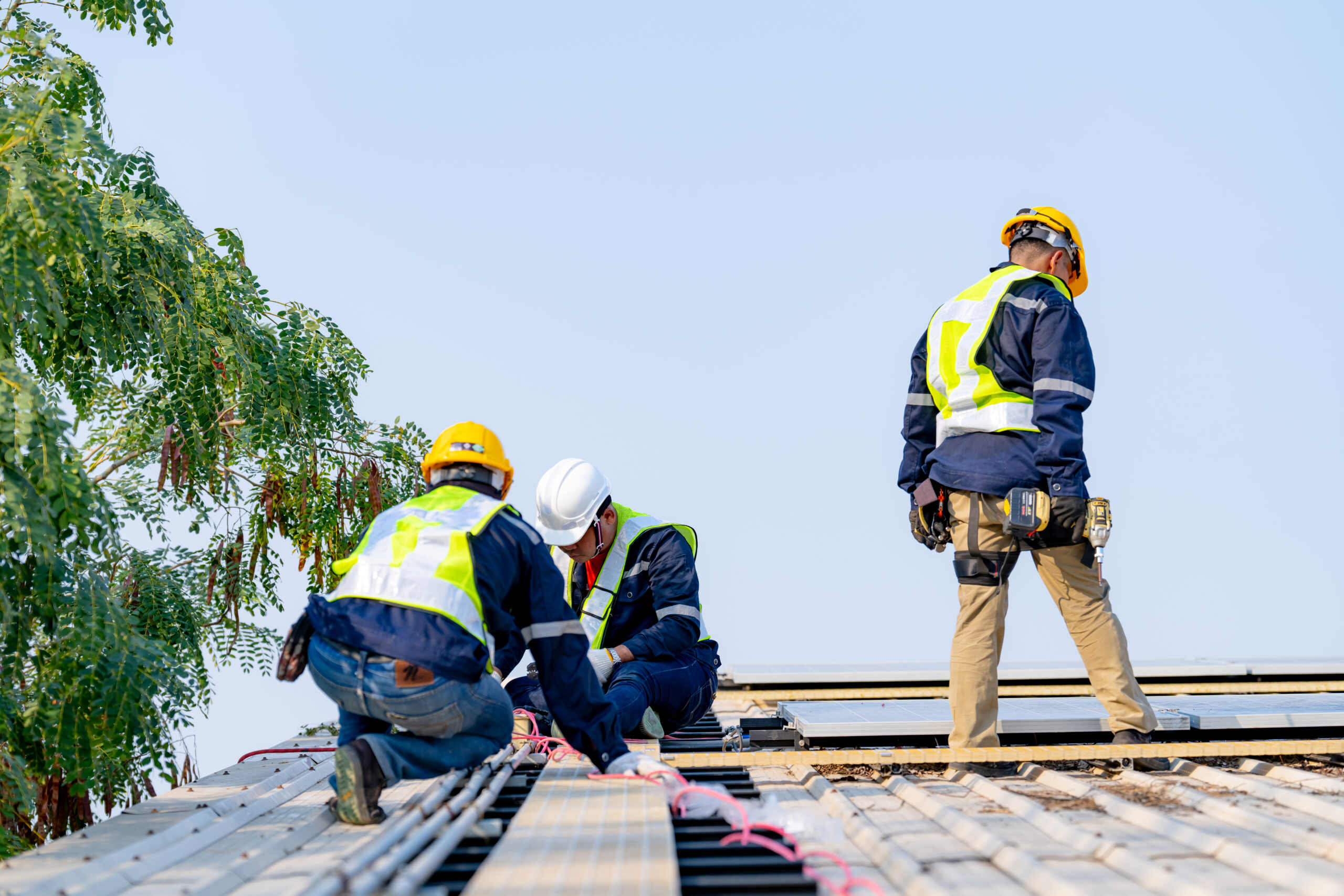 Roofing Services Lynn Heaven FL workers installing solar panels, for efficient energy on rooftop