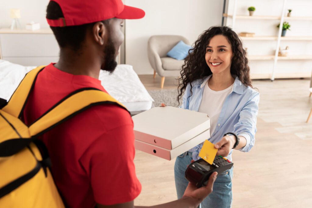Delivery Services in Glendora CA Deliveryman holding POS machine, satisfied client paying with card